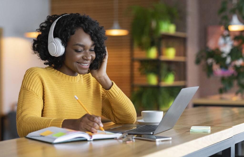 What’s a Virtual Tour like at AVEDA Institute Maryland woman on laptop with headphones 