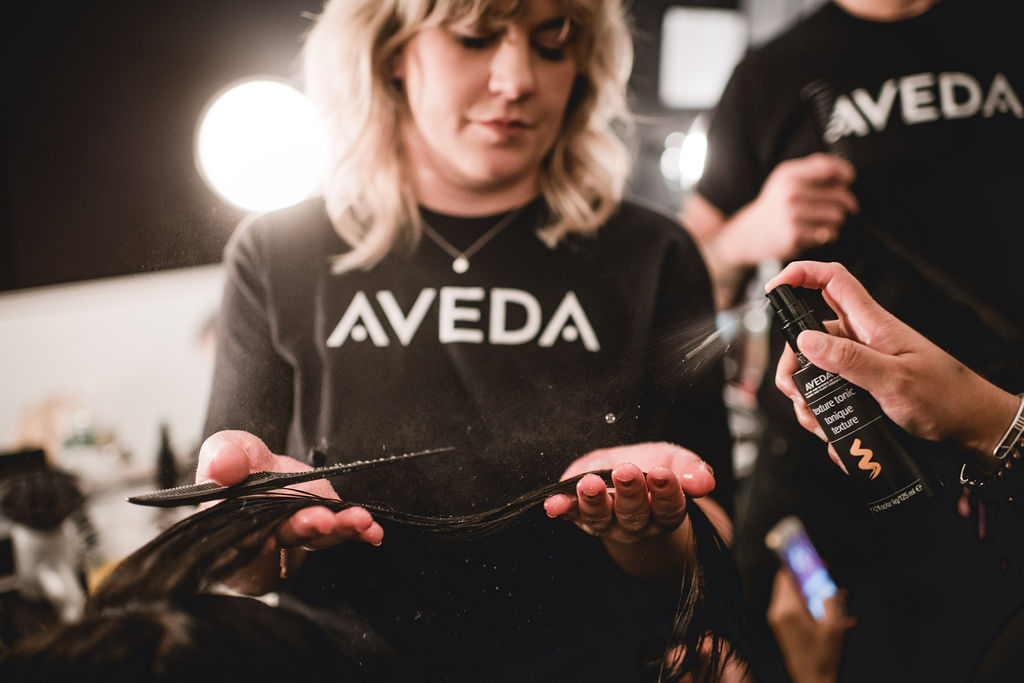 Hair Stylist in Maryland at Aveda applying hairspray